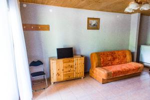 a living room with a chair and a desk with a laptop at Willa Magda in Okuninka