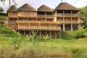 Kabale的住宿－Keije Resort Bunyonyi，一座带茅草屋顶的大型木制建筑,位于山上
