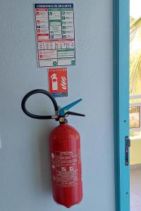 hydrant pożarowy jest przymocowany do ściany nożyczkami w obiekcie Calme Villa w mieście Sainte-Rose