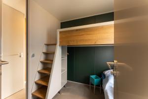 a small bedroom with a bunk bed and green walls at Boje 67 in Scharbeutz