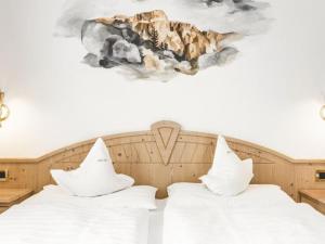 セルヴァ・ディ・ヴァル・ガルデーナにあるHotel Elseのベッドルーム1室(ベッド2台付)が備わります。壁には絵画が飾られています。