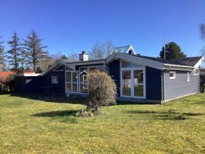 een klein blauw huis op een grasveld bij Holiday home Storvorde XXIII in Storvorde
