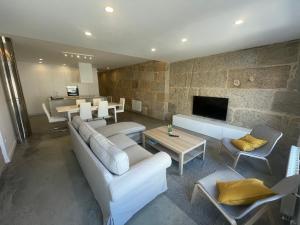 a living room with a couch and chairs and a tv at Corazón casco viejo in Vigo