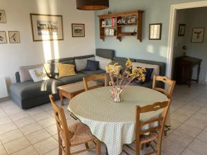 ein Wohnzimmer mit einem Tisch und einem Sofa in der Unterkunft Appartement vue sur mer Morgat centre in Morgat