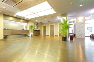 an empty lobby with a large room with plants at HOTEL MYSTAYS Kameido in Tokyo