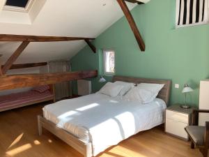 1 dormitorio con 1 cama blanca grande y paredes verdes en Le Loft, en Aubeterre-sur-Dronne