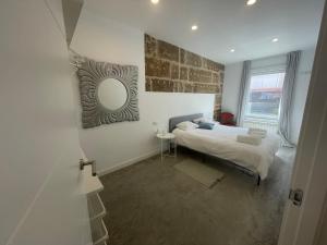1 dormitorio con cama y espejo en la pared en Corazón casco viejo, en Vigo