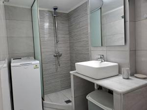 a white bathroom with a sink and a shower at Cozy Apartment in Nea Palatia-Oropos in Oropos