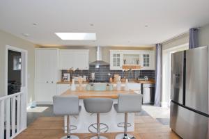 a kitchen with a table and a refrigerator at Luxury Home - Hot Tub - Pool Table - Cinema Room - Close to Beach in Bournemouth