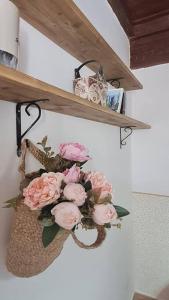 a bouquet of pink roses on a shelf at La Casina in Capodimonte