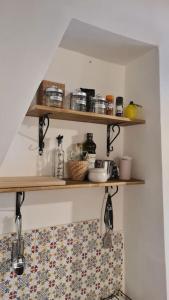 a kitchen with wooden shelves on the wall at La Casina in Capodimonte