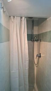 a shower with a white shower curtain in a bathroom at La Casina in Capodimonte
