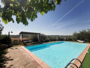 a large swimming pool in a yard with a table at Muralto - 5 Bedroom Villa with Panoramic Pool in Penna in Teverina