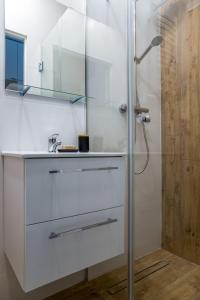 a white bathroom with a shower and a sink at ADLER Apartments in Łódź
