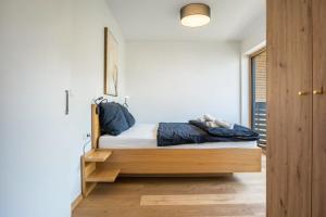 sypialnia z łóżkiem z drewnianą ramą w obiekcie Pension Grasser Apartment w mieście Auer