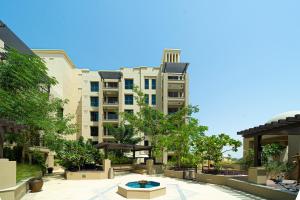 a large apartment building with a courtyard with trees at Classy One Bed, Burj Al Arab View, Beach Access in Dubai