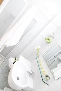 a white bathroom with a sink and a mirror at Hotel Orsa Maggiore in Milano Marittima +62 photos