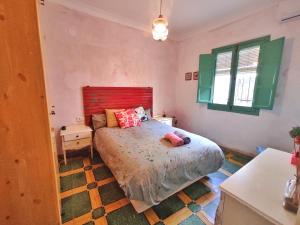 una camera con un grande letto con testiera rossa di Casa Dos Mareas a Isla Cristina