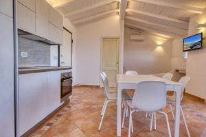 una cucina e una sala da pranzo con tavolo e sedie bianchi di Stella Marina- Luxury Sea View in Porto Cervo! a Porto Cervo