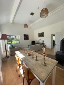 uma sala de estar com uma mesa de madeira e cadeiras em Newly renovated Cottage with private trout fishing set in beautiful wildlife estate em Monaghan