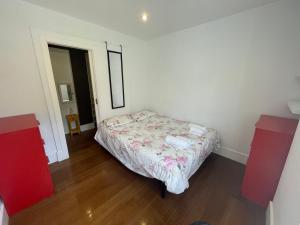 a small bedroom with a bed and two red cabinets at No podrás olvidarlo in Baiona