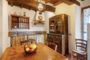 a kitchen with a wooden table with a basket of fruit at Universal Harmony - Poiana in Dicomano