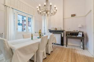 a dining room with a table and chairs and a chandelier at Oceanide - Gerenoveerde luxe villa vlak bij het strand in De Haan