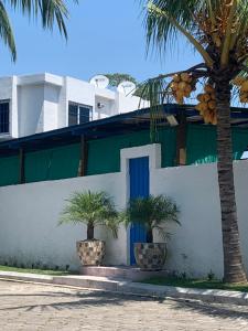 un edificio bianco con una porta blu e palme di Chalet Casa Vacacional Riveras de Chulamar a Puerto San José