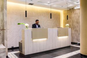 a man sitting at a reception desk in an office lobby at 1253 Recoleta Small Hotel in Buenos Aires