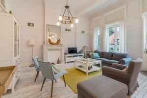 uma sala de estar com um sofá e uma mesa em Oceanide - Gerenoveerde luxe villa vlak bij het strand em De Haan