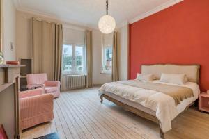 een slaapkamer met een bed en een rode muur bij Oceanide - Gerenoveerde luxe villa vlak bij het strand in De Haan