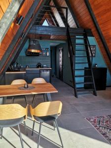 eine Küche und ein Esszimmer mit einem Holztisch und Stühlen in der Unterkunft Mirador Cottage in Slawske