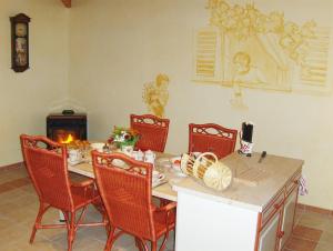 een eetkamer met een tafel en stoelen en een open haard bij La p'tite Boulonne in Festigny