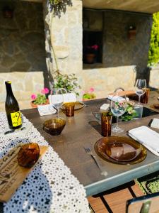 una mesa con copas y una botella de vino. en Ca la Carme, en Santa Pau