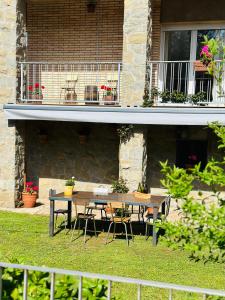 een tafel en stoelen voor een huis bij Ca la Carme in Santa Pau