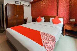 1 dormitorio con 1 cama grande con almohadas de color naranja y rojo en Flagship Hotel Grand Decor, en Jaipur