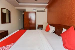 1 dormitorio con 1 cama con almohadas rojas y blancas en Flagship Hotel Grand Decor, en Jaipur