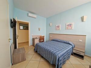 a bedroom with a bed with a blue comforter at La Conchiglia in Sperlonga