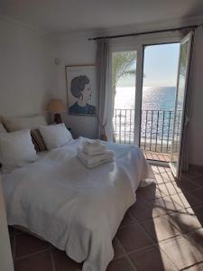 een slaapkamer met een bed en uitzicht op de oceaan bij Frontline Beach Apartment, La Perla de la Bahia, Bahia de Casares - Estepona in Casares