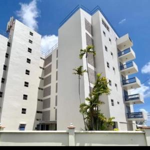 two tall white buildings with palm trees in front of them at 1B Hastings Towers in Bridgetown