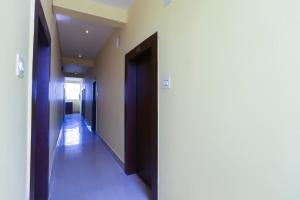 a hallway with a door leading to a hallway with white walls at OYO Hotel Shree Balajee 1 in Puri