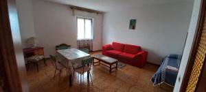 un soggiorno con divano rosso e tavolo di Appartamento con 2 camere in borgo medievale a Montegiovi