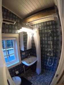 a bathroom with a sink and a shower and a tub at Gaulabua - cozy cabin by the river Gaula 