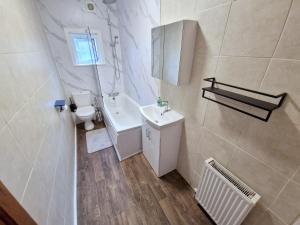 a small bathroom with a sink and a toilet at Two bedroom apartment near Lewisham Station in London