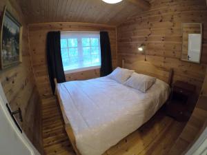 a bedroom with a bed in a log cabin at Gaulabua - cozy cabin by the river Gaula 