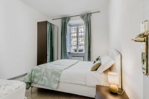 a white bedroom with a bed and a window at Trastevere’s Flower 