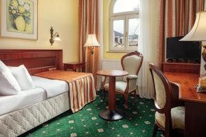 ein Hotelzimmer mit einem Bett, einem Schreibtisch und einem Tisch in der Unterkunft Humboldt Park Hotel & Spa in Karlsbad