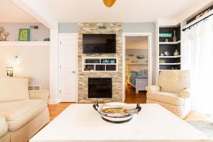 sala de estar con chimenea de piedra y TV en Ocean Glass Condominiums en Rehoboth Beach