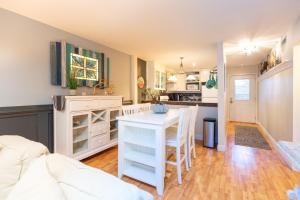 eine Küche und ein Wohnzimmer mit einem weißen Tisch und Stühlen in der Unterkunft Ocean Glass Condominiums in Rehoboth Beach