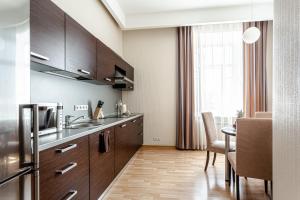 a kitchen with wooden cabinets and a table in a room at Senator Victory Square in Kyiv